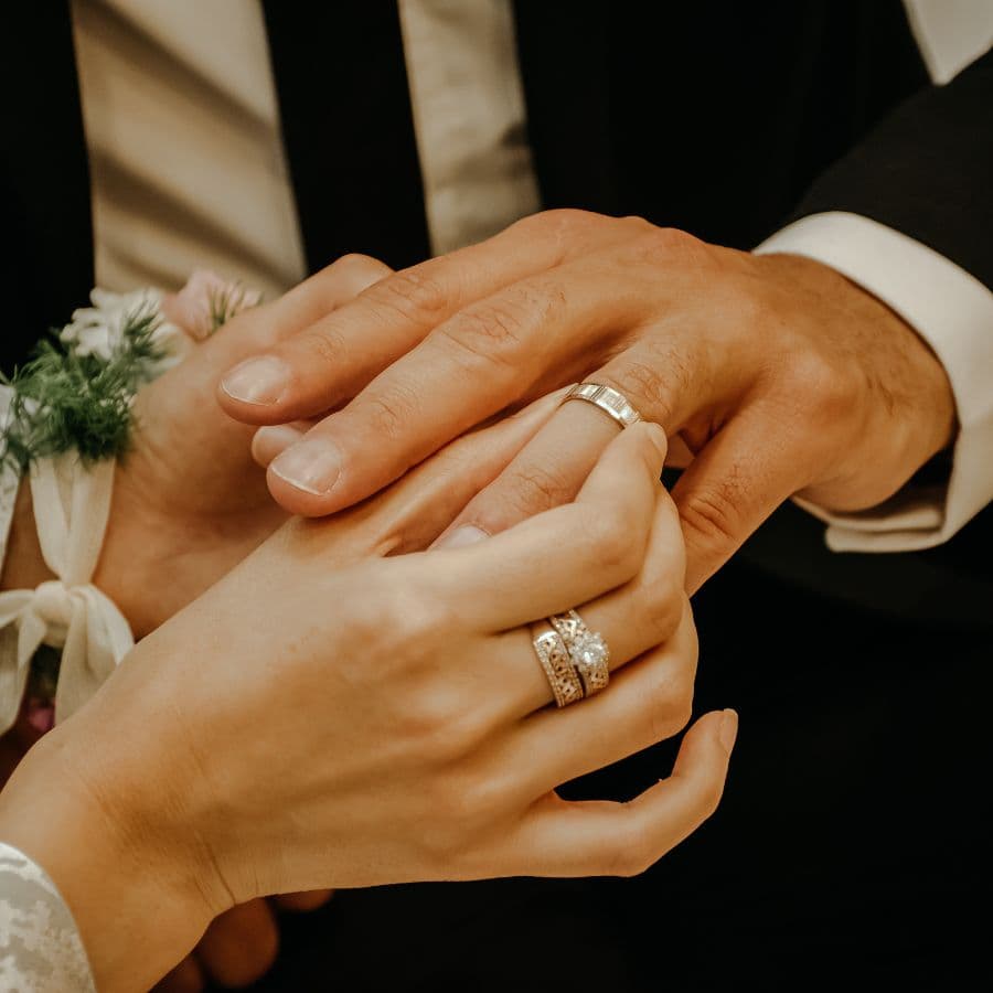 Two hands with wedding rings intertwined.