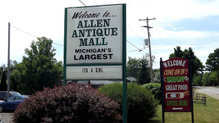 green and white welcome to allen antique mall sign