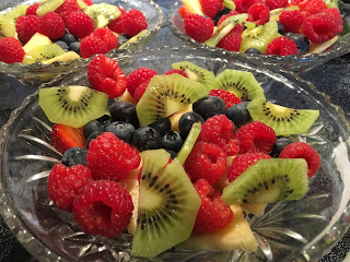 glass bowl of fresh cut fruit for breakfast Fresh fruit bowl with red raspberries blueberries pineapple green kiwi