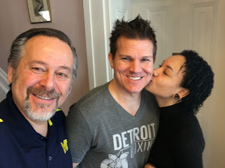 male and female guest with innkeeper innkeeper selfie with man in gray tigers shirt kissed by woman