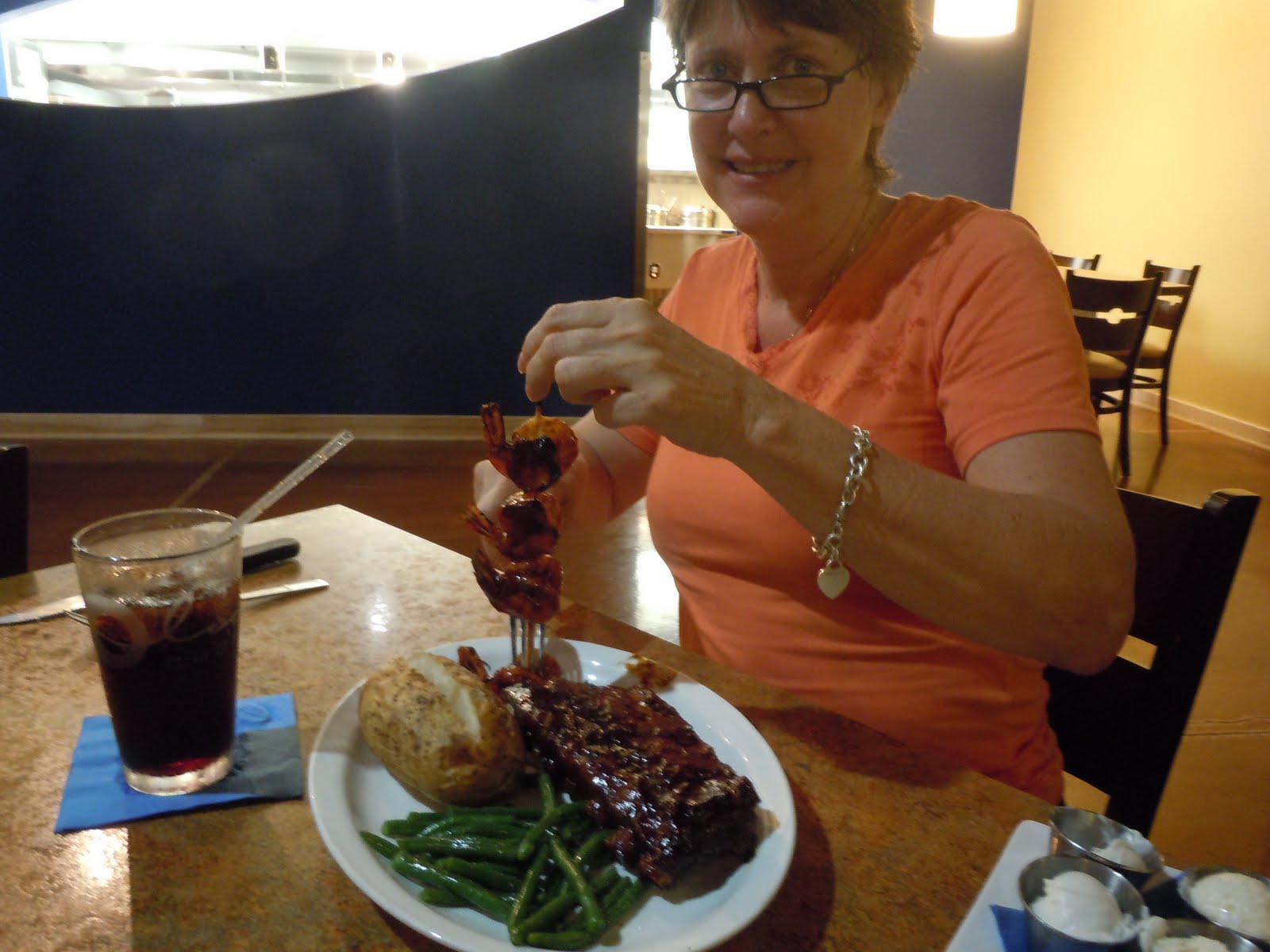 woman enjoying a steak and shrimp dinner