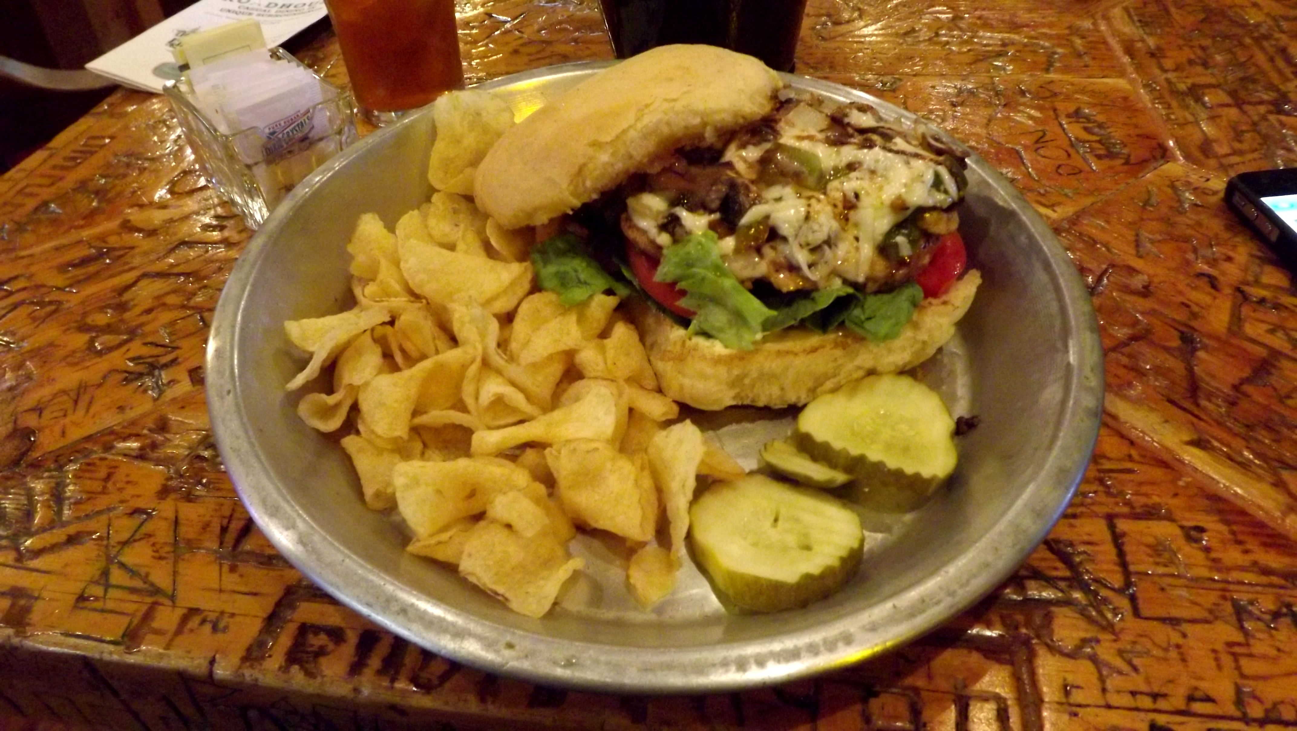 sandwich with chips on a tin plate with graffiti carved table