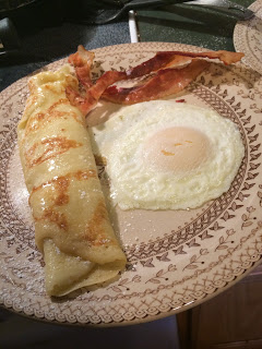 Fried egg over easy, German pancake, bacon on vintage stone wear