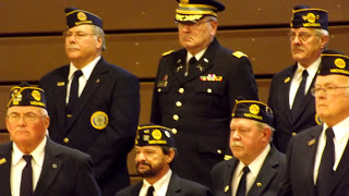 Veterans in uniform at attention during veterans day program