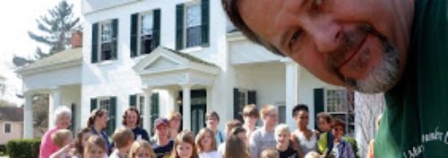 man with many kids in front of big old white house