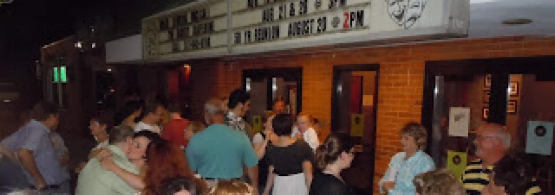 crowd gathering outside theater with marquee