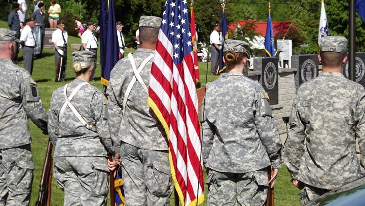rear view of military personnel in camouflage uniforms with american flag