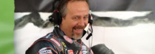 nascar man with headphones and sponsors uniform