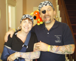 Man and woman with dew rags and tattoo sleeves with an orange dog perched on his shoulder