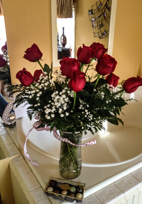 Red roses floral bouquet on the edge of a Jacuzzi tub