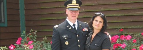 veteran with wife and red flowers in bloom