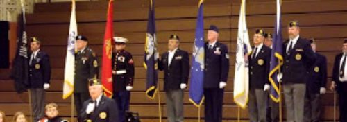 veterans at attention holding flags