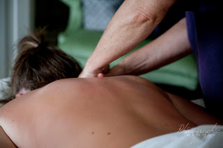 in room massage therapy masseuse performing massage on bareback woman in green room